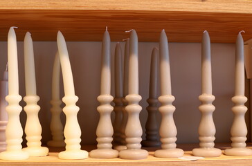 Fototapeta premium A burning wax candle stands on the table.