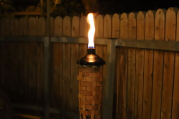 A burning wax candle stands on the table.