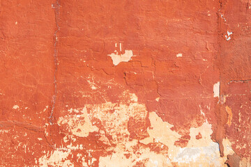 Red wall of an old building with aged plaster. Close-up. Background.