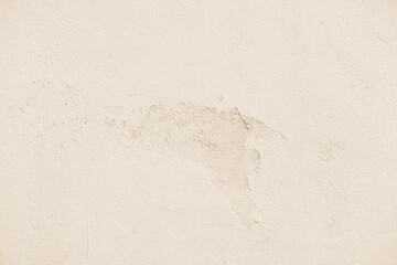 Dirty cream concrete wall peeling cracked paint. Uneven render cement wall. Grunge and rough surface.
