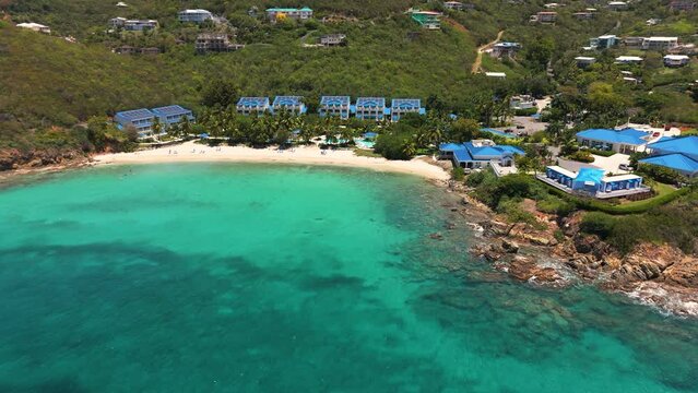 rotating capture of beautiful hotel resort with blue roofs remodeled after the hurricane in st. thomas virgin islands from a drone in the tropics