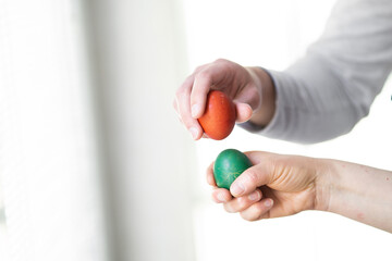 easter egg tapping, close up of two hands egg tapping, mother and son egg tapping