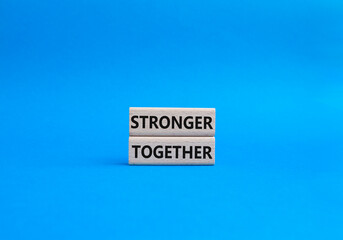Stronger together symbol. Wooden blocks with words Stronger together. Beautiful blue background. Stronger together concept. Copy space.