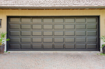 Garage door in luxury house with trees and nice landscape in Vancouver, Canada.