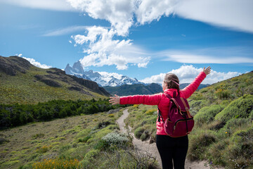 Mujer alzando los brazos y disfrutando de su recorido por los senderos de El Chalten, en Argentina