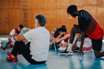 Hispanic basketball player stretching before match or training in a sports hall