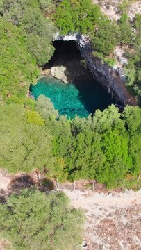 Famous Melissani lake on Kefalonia island, Karavomylos, Greece. Aerial view of the Melissani Cave lake in Karavomylos village on Cephalonia island , Greece. Zoom out drone footage