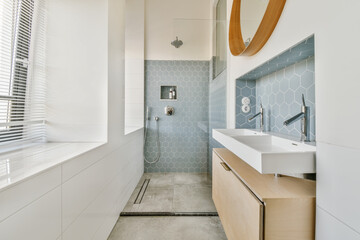 Modern bathroom with blue hexagonal tiles and wooden accents