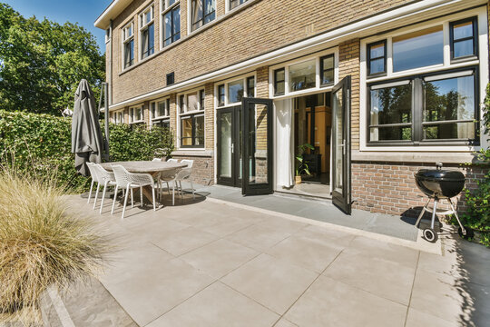 Sunny patio area with open doors and modern furniture