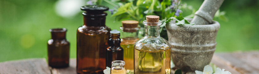 Eco friendly pure skin care organic product. Beauty treatment, spa bath concept. Cosmetic products with natural ingredients. Glass bottles with herbal essence extract on wooden background.