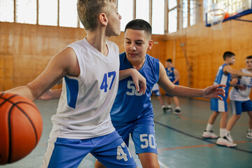 Junior basketball players in action playing basket on training.