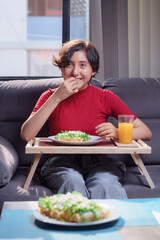 Young girl eating traditional fried tacos and she smiles at the camera. Mexican food