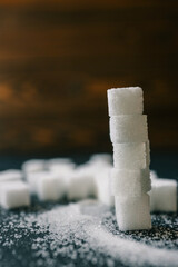 White crystalline sugar cubes on a wooden spoon