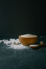 White crystalline sugar cubes on a wooden spoon