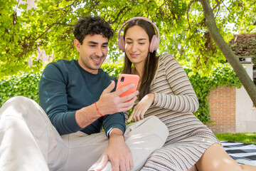 Young couple enjoying time together outdoors with smartphone
