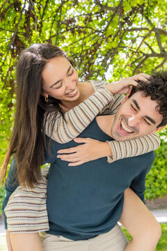 Joyful couple enjoying a playful moment in a green park