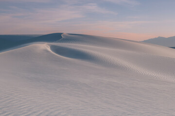 Wavelets on white sand dunes with sunset colors