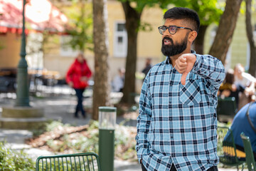 Dislike. Upset Indian bearded man showing thumbs down sign gesture, expressing discontent...