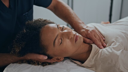 Closeup osteopath hands healing patient trauma. Relaxed woman lying on session