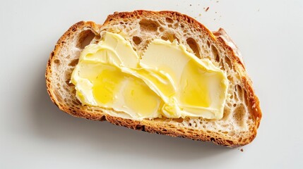 Top view of a piece of bread with butter on a white background