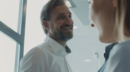 Obraz premium Business leaders or professional managers dressed in business attire happily communicate in the office, against a blurry white office background