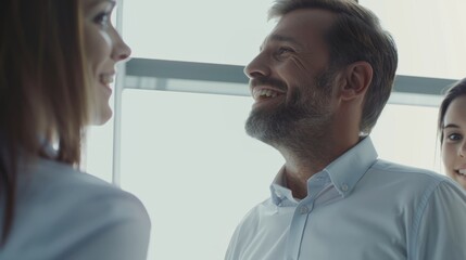 Obraz premium Business leaders or professional managers dressed in business attire happily communicate in the office, against a blurry white office background