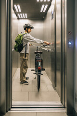 Teenager in the elevator with his bicycle, morning routine concept © Amparo Garcia