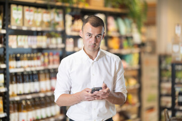 Mans eyes scan room bio supermarket store, searching something, product item to buy. Man buyer with...