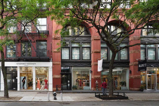 Row of fashion shops on tree lined street in Soho district of Manhattan