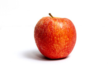Fresh red apple with yellow dots, and brown stem, close-up, on a white background