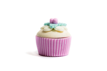 Ornamental toy-type decoration object in the shape of a cupcake, muffin, in a pink cup, with flowers on top and on a white background