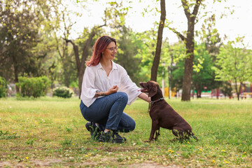 Woman with her cute German Shorthaired Pointer dog in park on spring day