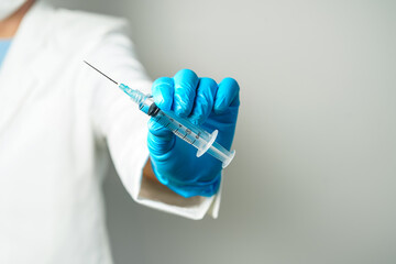 doctor or scientist holding a syringe in blue gloves