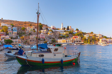 Panoramic view of colorful houses and boats in the harbor of Symi Island, Greece, at sunset