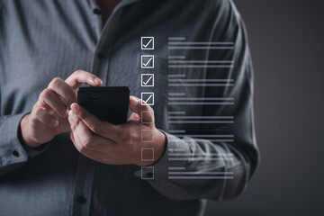 Businessman holding smartphone tick correct sign mark for document approve , project acceptance and quality assurance concept, Take an assessment, questionnaire, evaluation, online survey online exam.