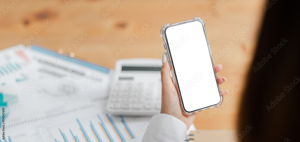 Aufkleber a person is holding a cell phone with a white screen. the phone is on a table with a calculator and 