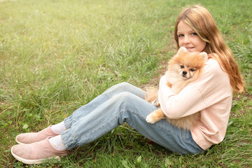 Fototapeta premium cute girl plays with a dog in nature. pets in the family
