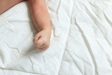 Portrait Of Cute Newborn Baby Hand On The White Bedsheet