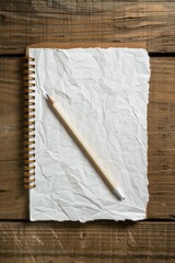 A blank white notebook with a pencil is on a wooden table background, viewed from above. It's presented in a minimal concept.