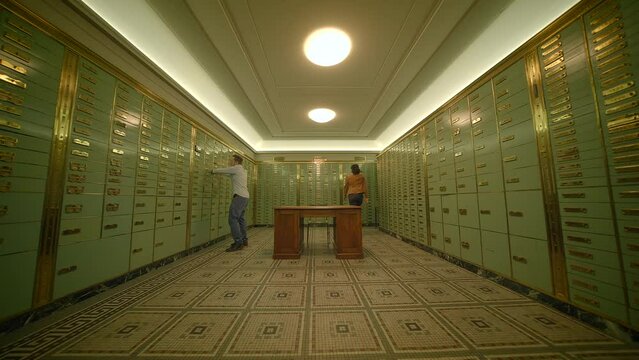 People are entering a room with safe deposit boxes to secure valuable assets in a safe environment