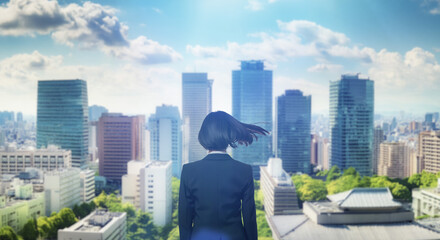 日本の街・都市・朝日を受けたオフィスビル群を前に佇み風を受けて髪をなびかせるスーツを着た会社員の女性の出勤　ビジネス・はじまり・決意・目標・挑戦のイメージ