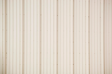 Vertical panels of beige tin cladding as a background texture