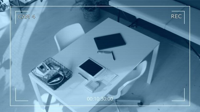 No people CCTV overhead shot of doctors desk in GP clinic, with laptop, digital tablet, blood pressure monitor, diagnostic equipment, thermometer, jar of pills, eye exam torch, couch, in evening