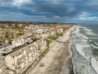 Aerial view of Carlsbad promenade, oceanside villas, holiday rentals with cloudy sky