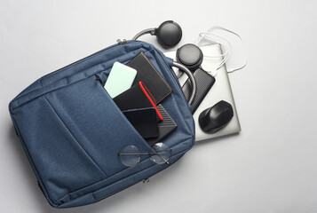 Laptop with Modern gadgets and accessories for work and study in Backpack on white background.
