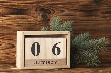 Wooden block calendar with date january 06 and pine tree on wooden background