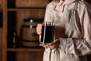 Woman with mug of tasty kvass in storage