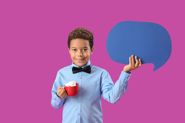 Little African-American boy holding cup of hot chocolate with marshmallows and speech bubble on...