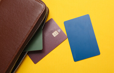 Leather wallet with credit cards on a yellow background