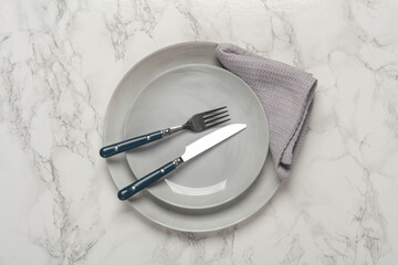 Plates, cutlery with towel on marble background. Table setting. Top view